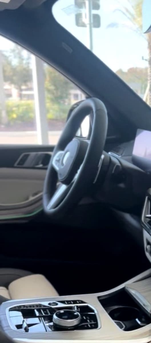 BMW X7 — curved display, open cabin, and coastal light through the glass