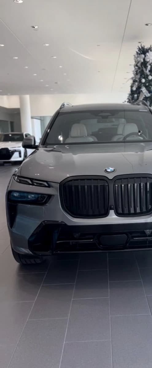 2023 BMW X7 xDrive40i — silver flagship SUV in showroom lighting